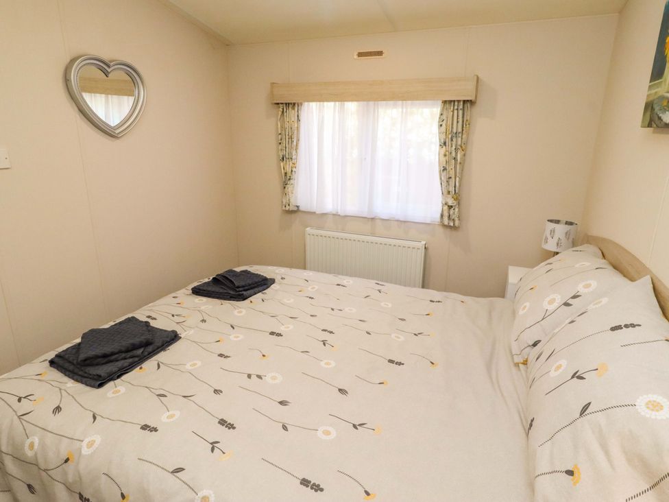 A bedroom with a bed and a window at Gardeners Lodge