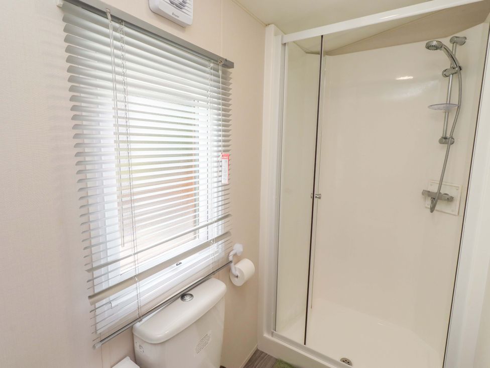 A bathroom with a shower and toilet at Gardeners Lodge
