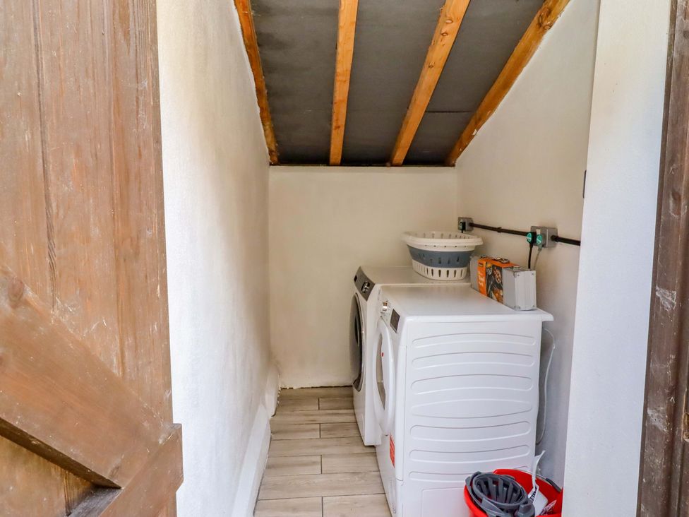 A laundry room with a washing machine and dryer at Gardeners Lodge