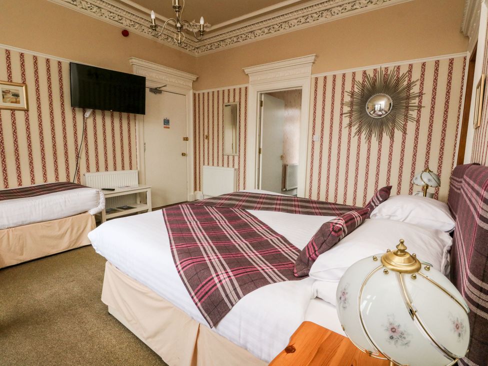 A bedroom with two beds and a television at Seaview Wellness Retreat, Carnoustie