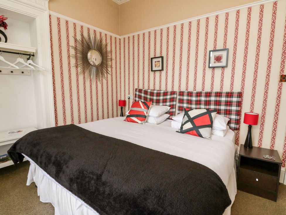 A bedroom with a bed and bedside lamp at Seaview Wellness Retreat in Carnoustie