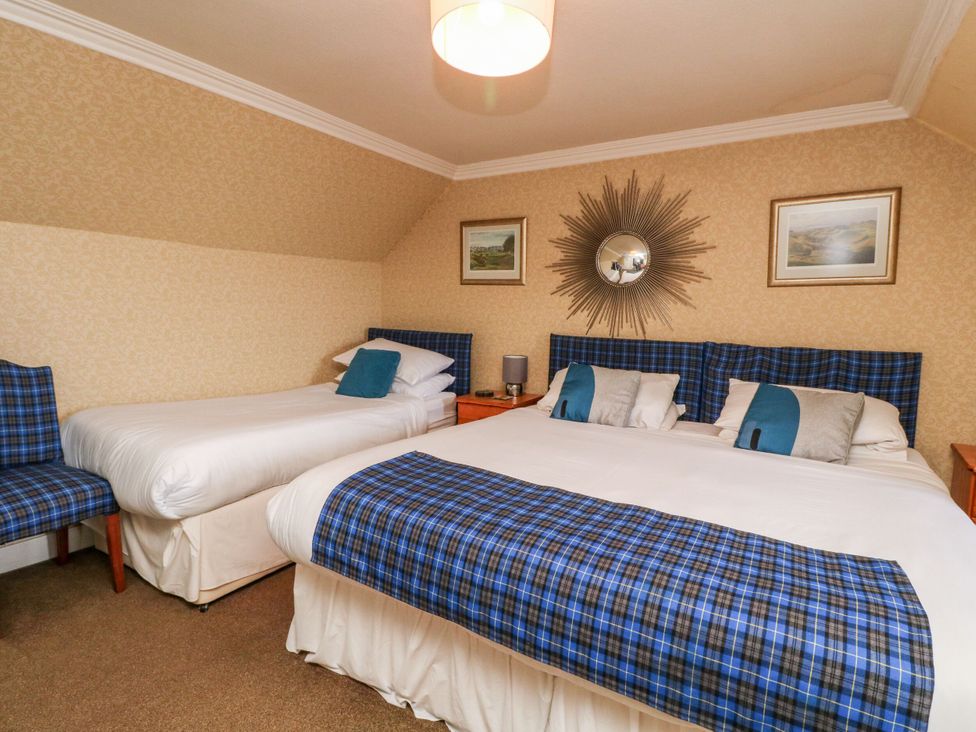 A bedroom with two beds and a chair at Seaview Wellness Retreat in Carnoustie
