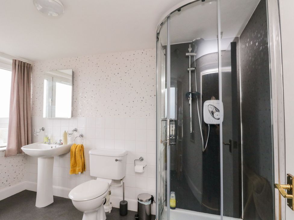 A bathroom with a shower, sink, and toilet at Seaview Wellness Retreat in Carnoustie