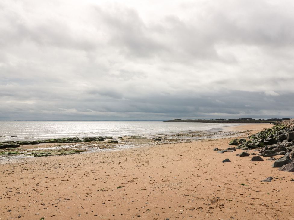 A beach scene with sand and rocks at Seaview Wellness Retreat in Carnoustie