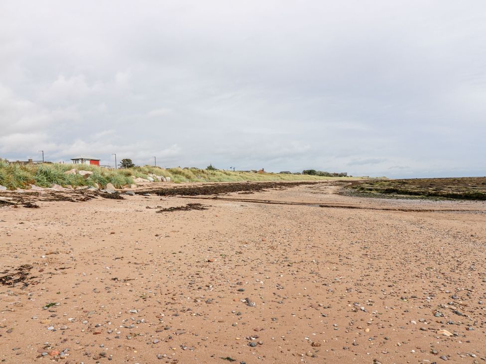 A beach with sand and rocks at Seaview Wellness Retreat in Carnoustie