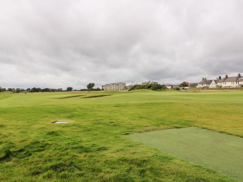 A golf course with buildings in the background at Seaview Wellness Retreat in Carnoustie
