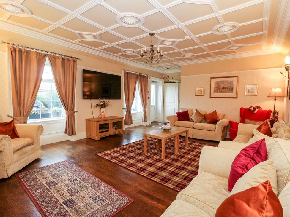 A living room with a sofa and television at Seaview Wellness Retreat in Carnoustie