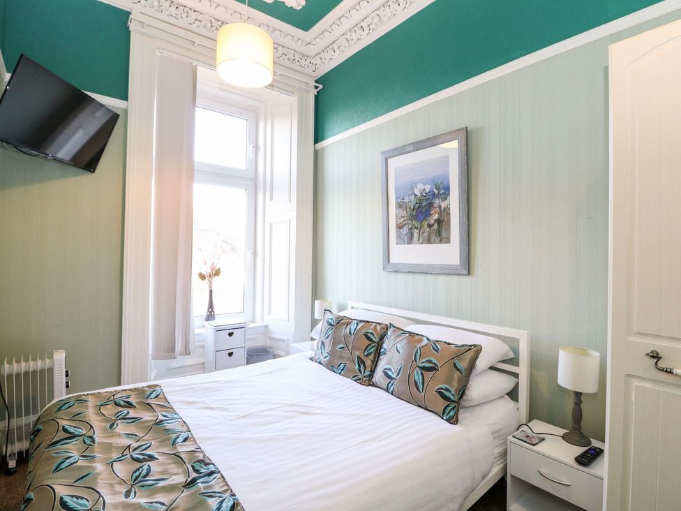 A bedroom with a bed and a television at Seaview Wellness Retreat in Carnoustie