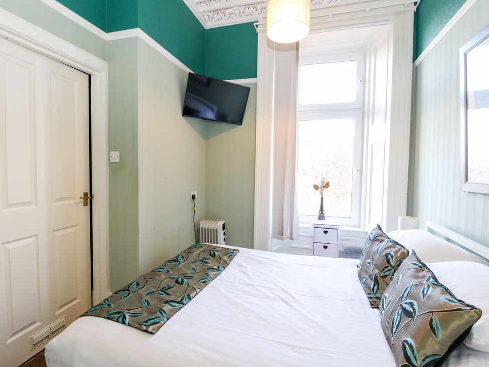 A bedroom with a bed and television at Seaview Wellness Retreat in Carnoustie