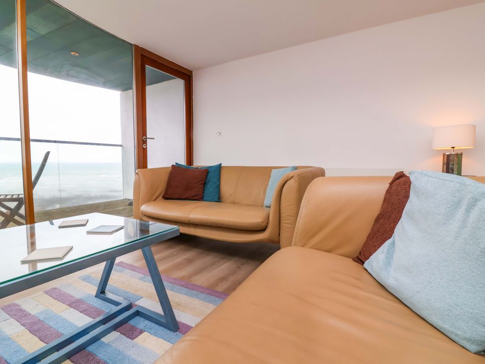 A living room with a glass coffee table and sofas at 12 Nautilus in Westward Ho!