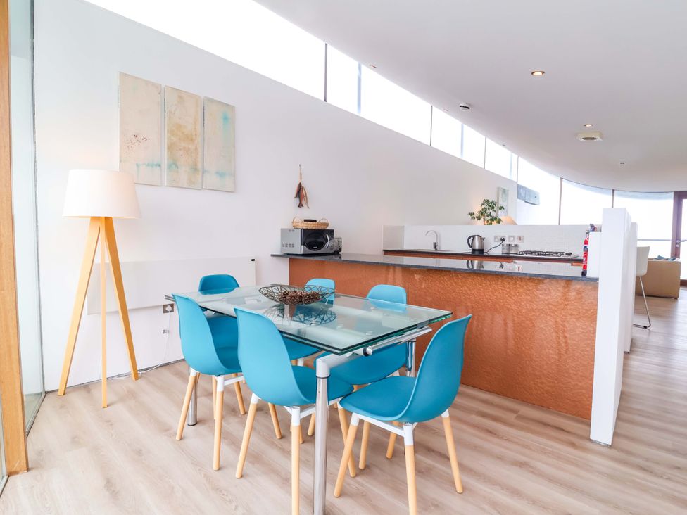 A dining room with a table and chairs at 12 Nautilus in Westward Ho!