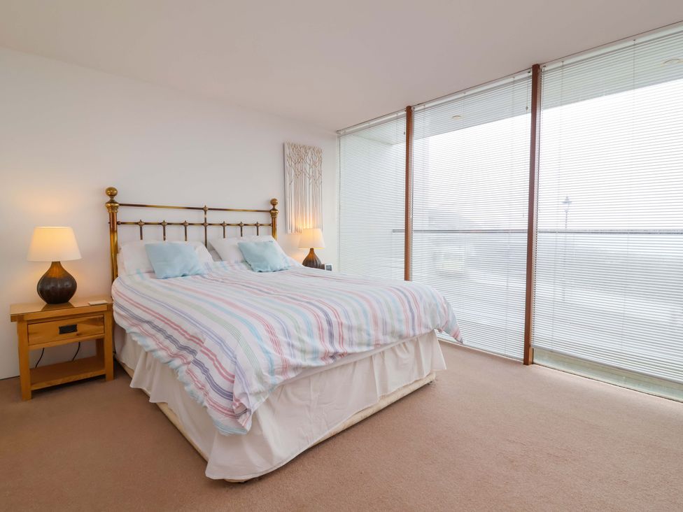 A bedroom with a bed and nightstand at 12 Nautilus in Westward Ho!