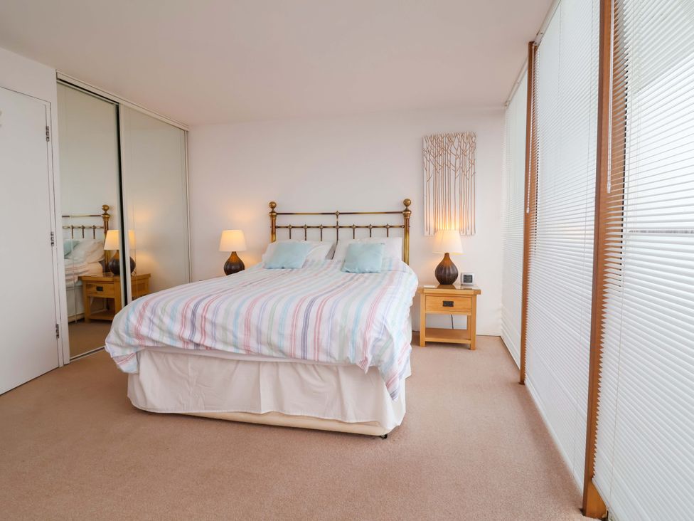 A bedroom with a bed and nightstand at 12 Nautilus in Westward Ho!