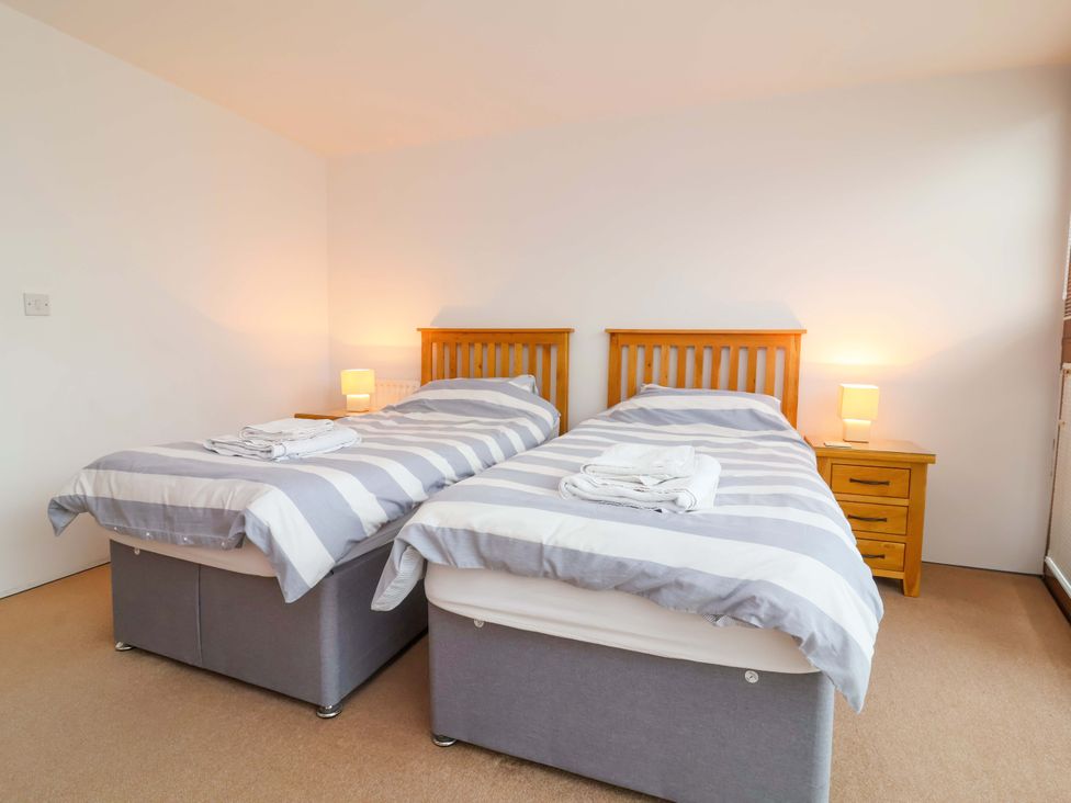 A bedroom with two beds and nightstand at 12 Nautilus, Westward Ho!