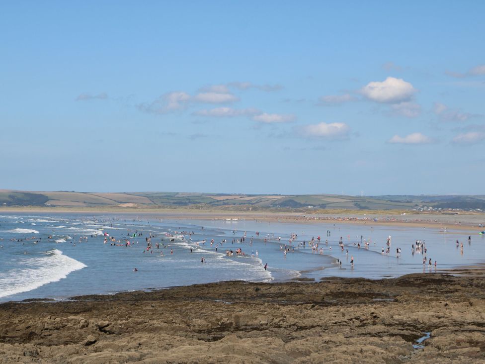 A beach with people wading in water at 12 Nautilus in Westward Ho!
