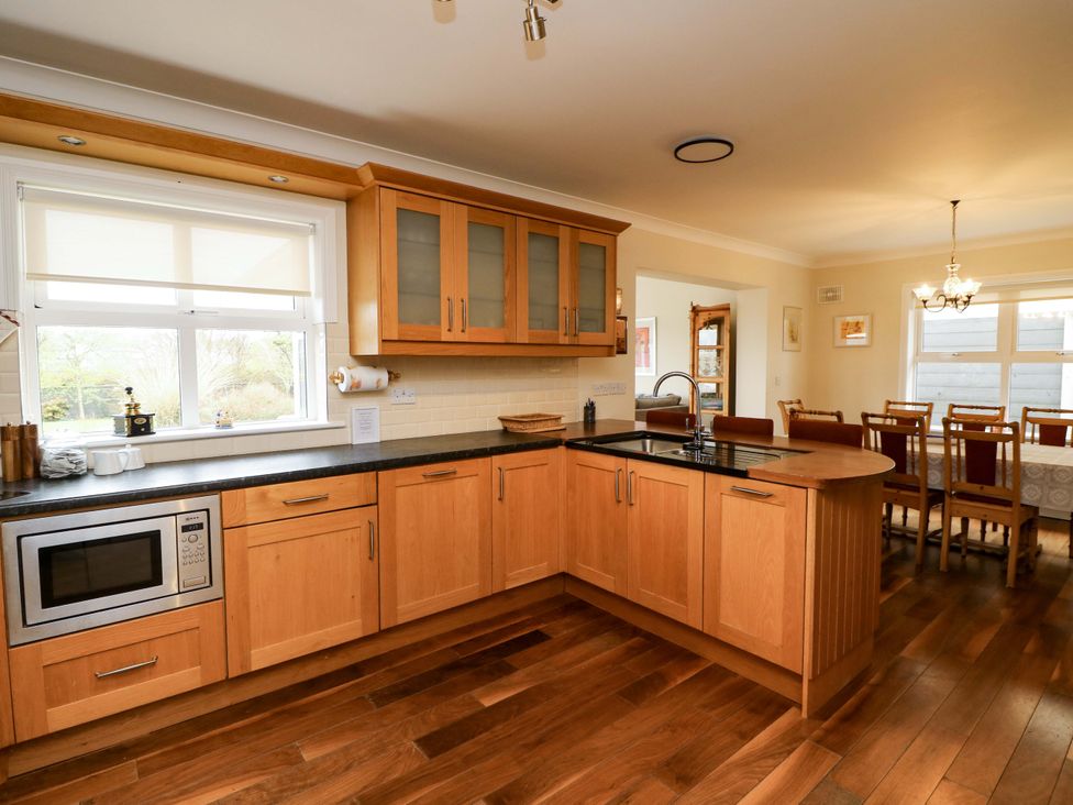 A kitchen with wooden cabinets and a dining area at Sunnyside in River Chapel