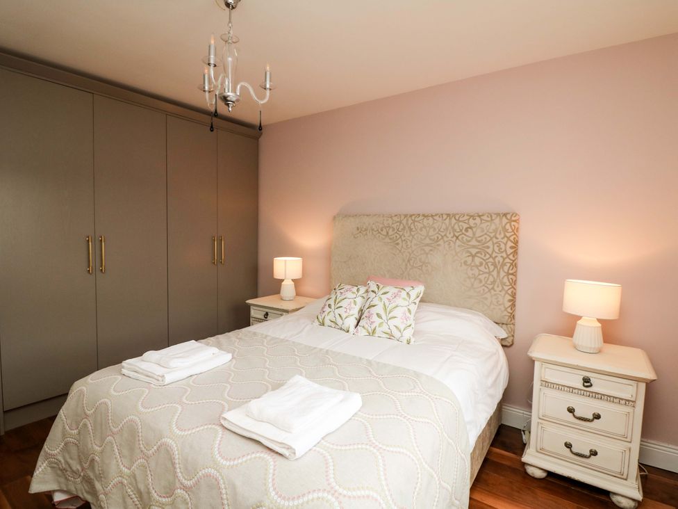 A bedroom with a bed, bedside tables, and wardrobe at Sunnyside in River Chapel