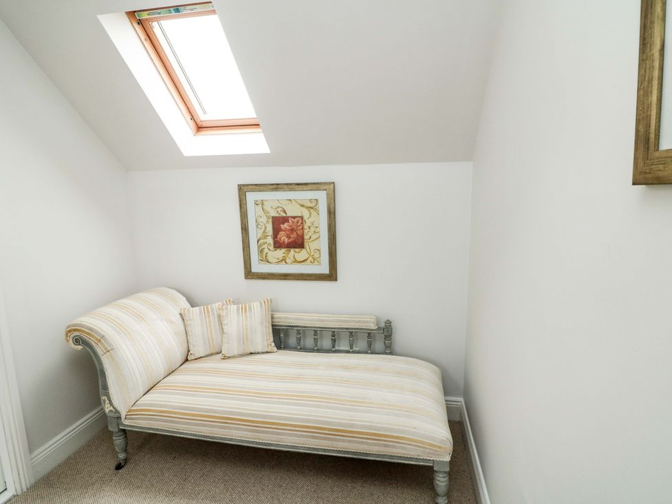 A chaise longue with cushions and framed artwork at Sunnyside in River Chapel