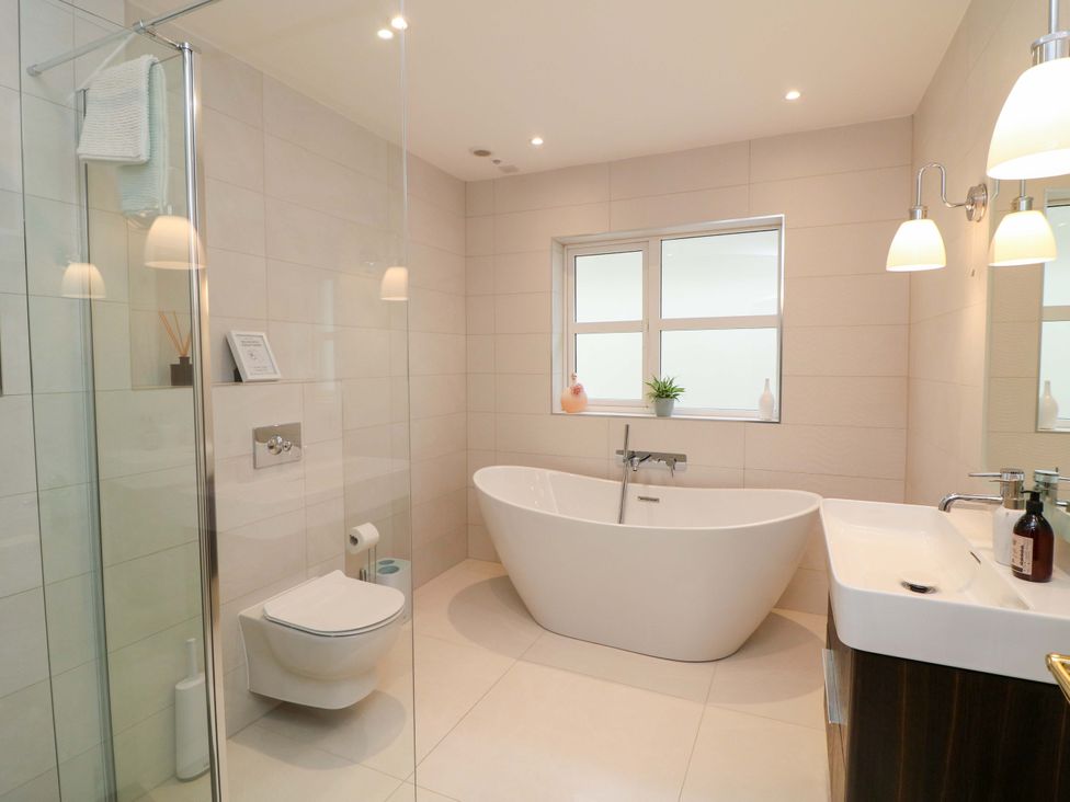 A bathroom with a bathtub, shower, sink, and toilet at Sunnyside in River Chapel