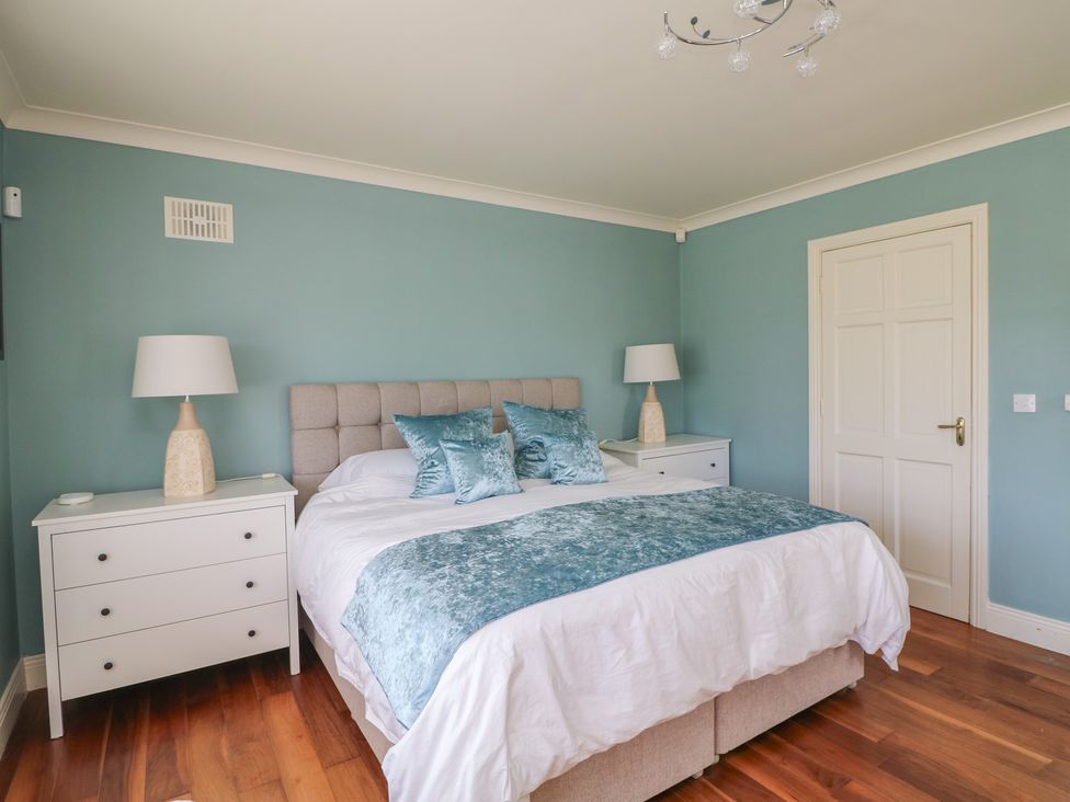 A bedroom with a bed and bedside table at Sunnyside in River Chapel near Courtown, County Wexford