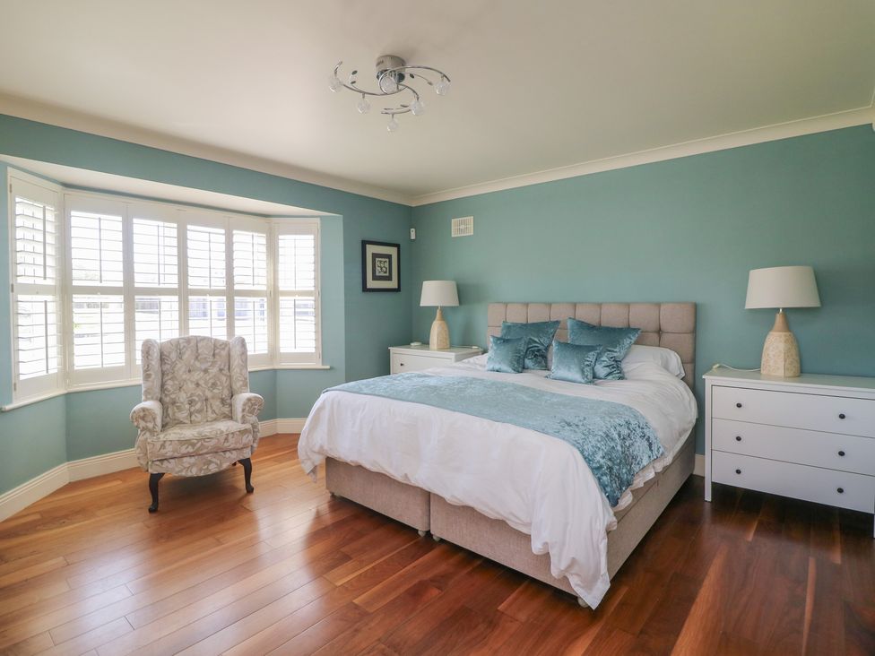 A bedroom with a bed and nightstands at Sunnyside, River Chapel near Courtown, County Wexford