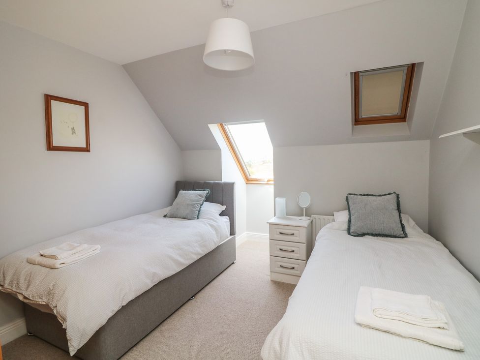 A bedroom with two beds and a window at Sunnyside, River Chapel near Courtown, County Wexford