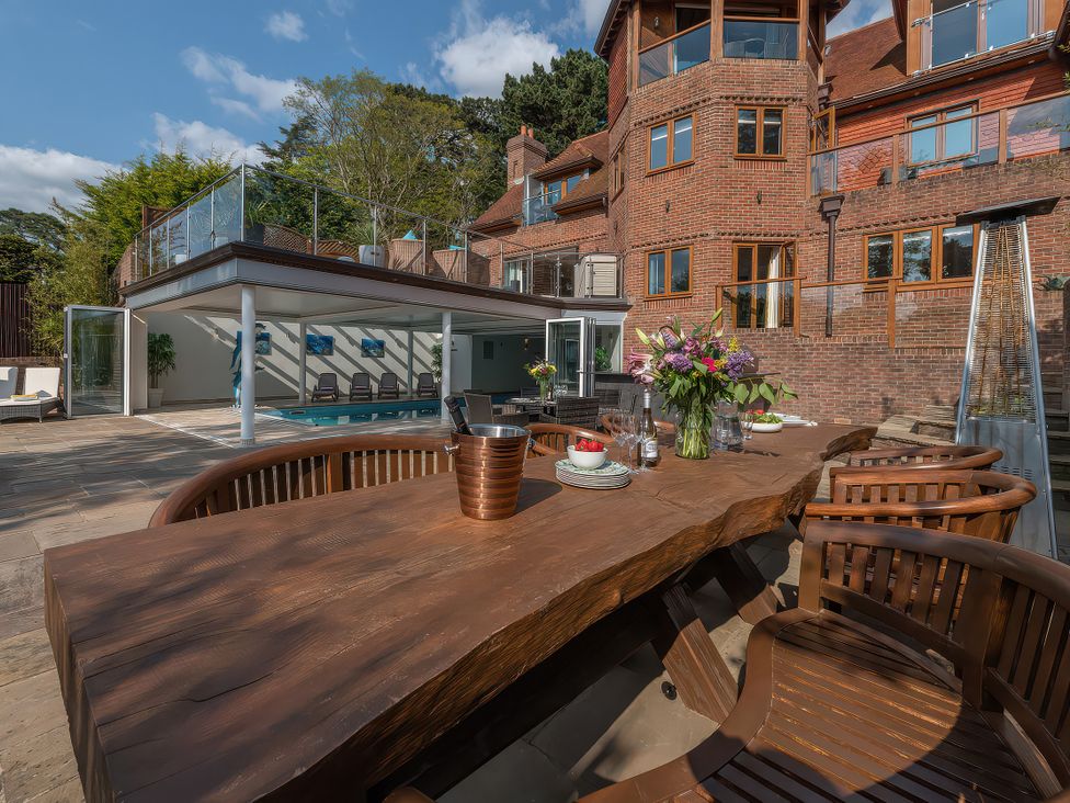 An outdoor seating area with a wooden table and chairs at Hamble House Southampton