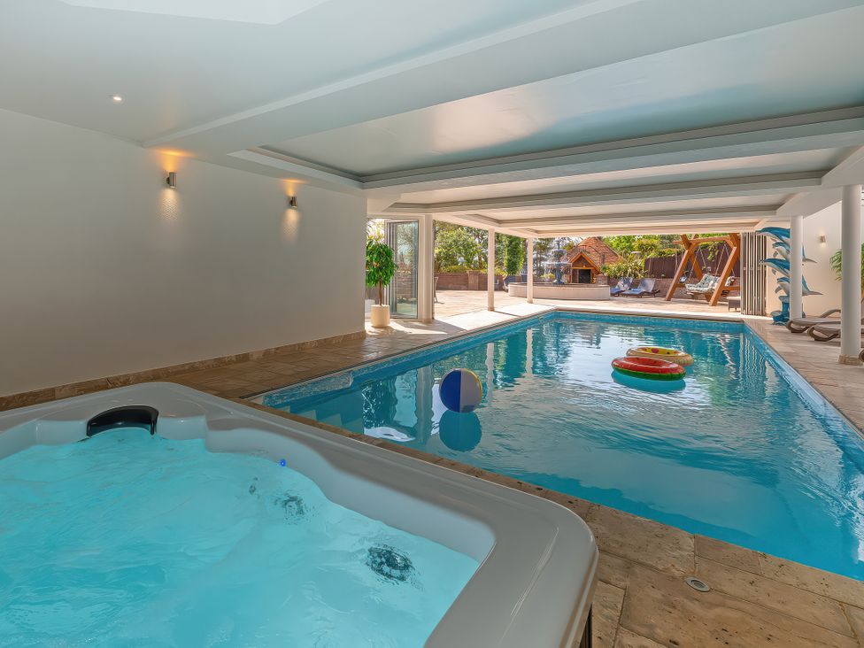 An indoor swimming pool with a hot tub and floating objects at Hamble House in Southampton