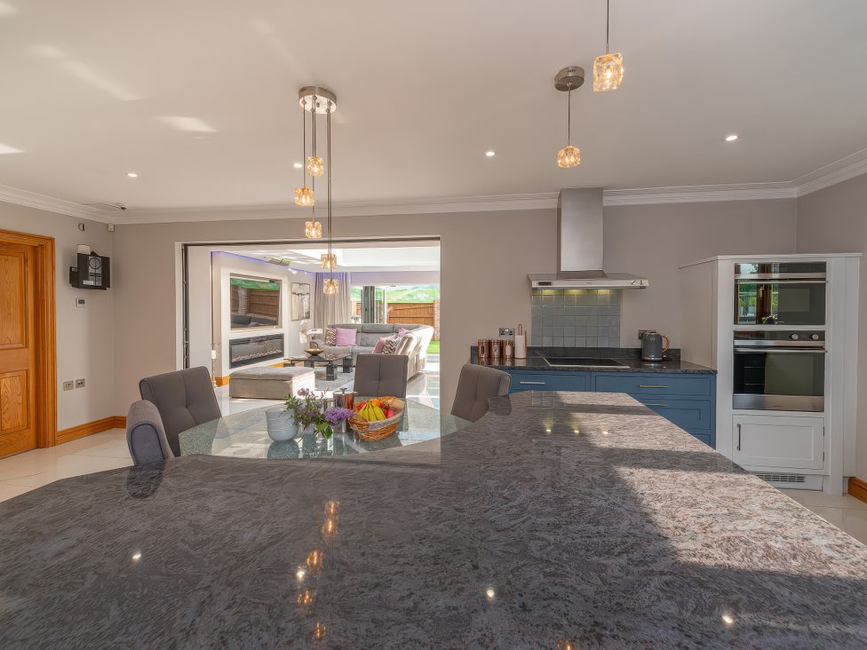A kitchen with an island and stools at Hamble House in Southampton