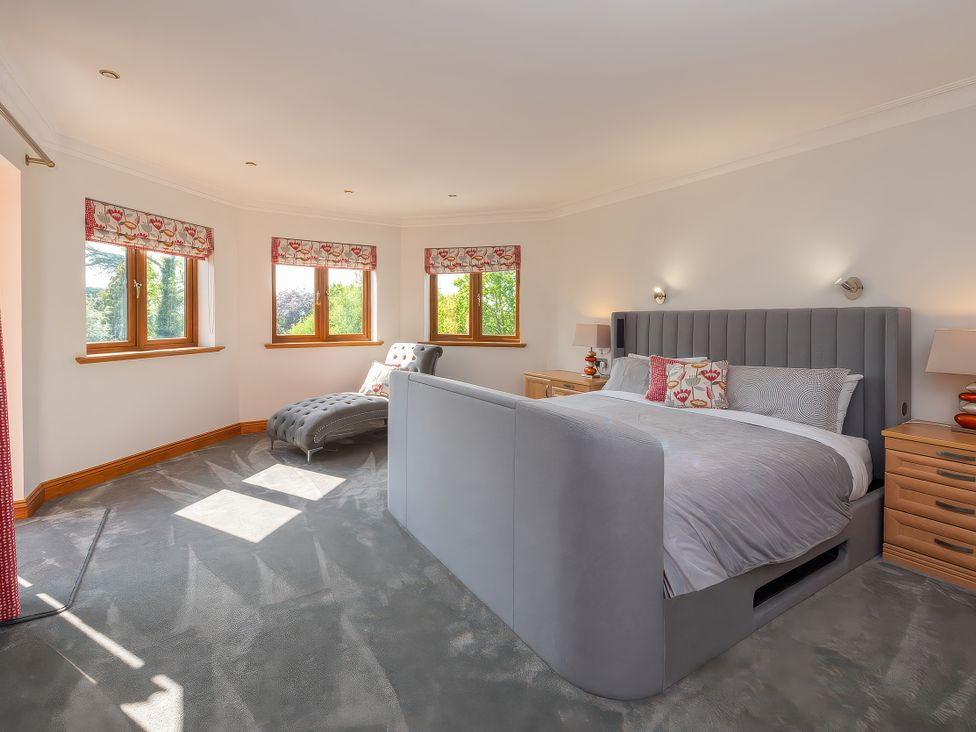 A bedroom with a bed, nightstand, and chaise lounge at Hamble House Southampton