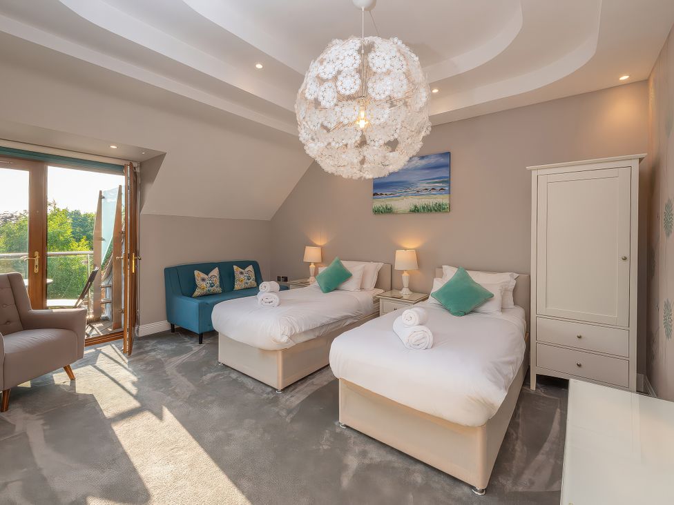 A bedroom with two beds and an armchair at Hamble House in Southampton