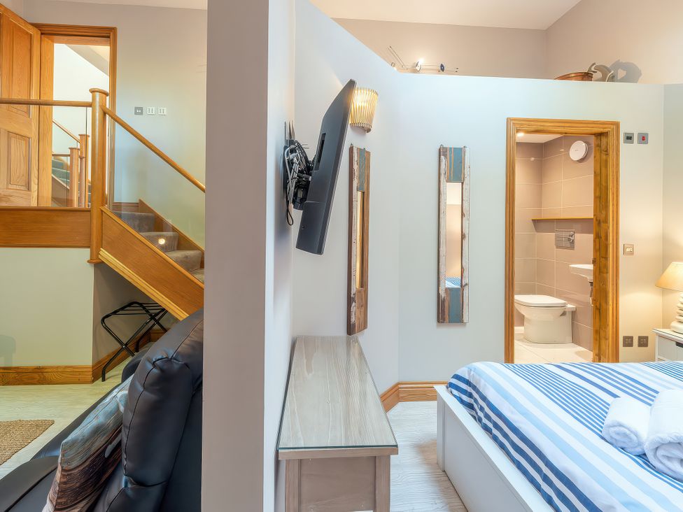 A bedroom with a television and mirrors at Hamble House in Southampton