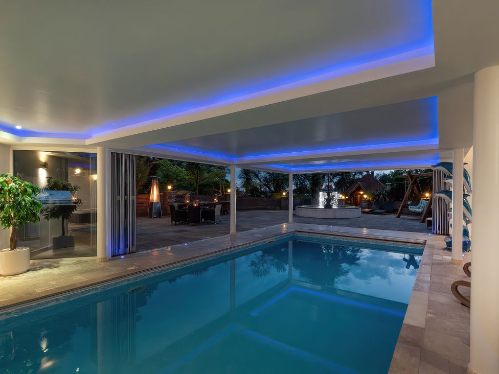 An indoor pool area with seating and a water feature at Hamble House in Southampton