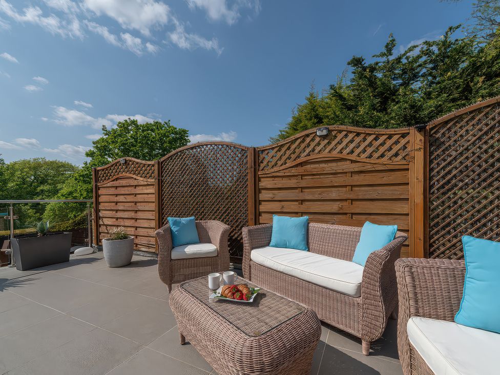 An outdoor seating area with wicker furniture at Hamble House Southampton
