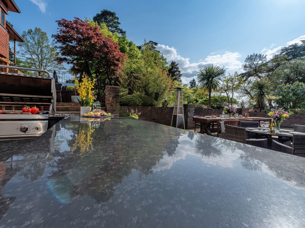A garden with a grill and dining area at Hamble House in Southampton
