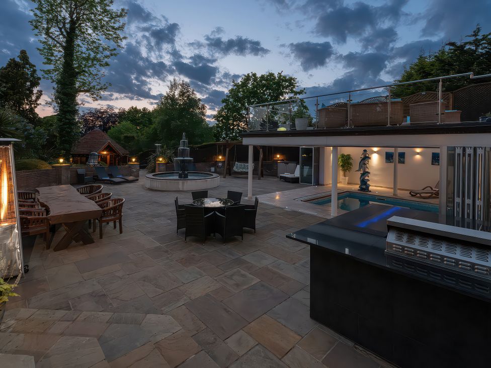 An outdoor area with a swimming pool and dining setup at Hamble House Southampton