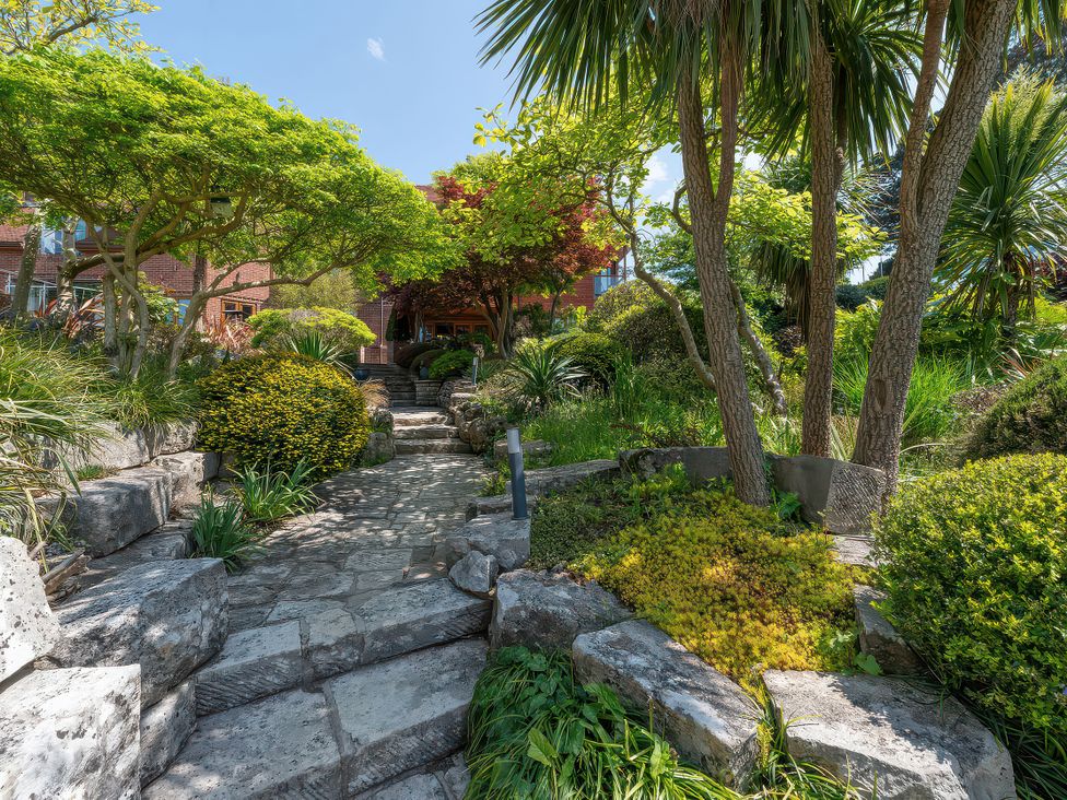 A garden with a stone pathway and various plants at Hamble House in Southampton