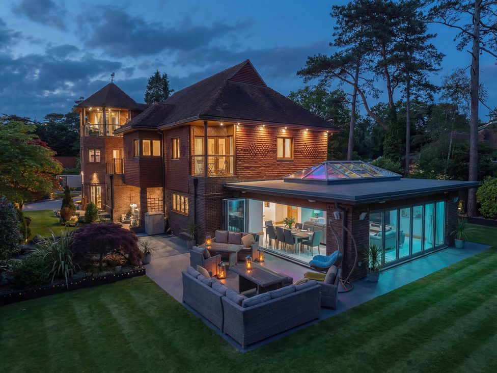 A house with outdoor seating and glass doors at Hamble House in Warsash