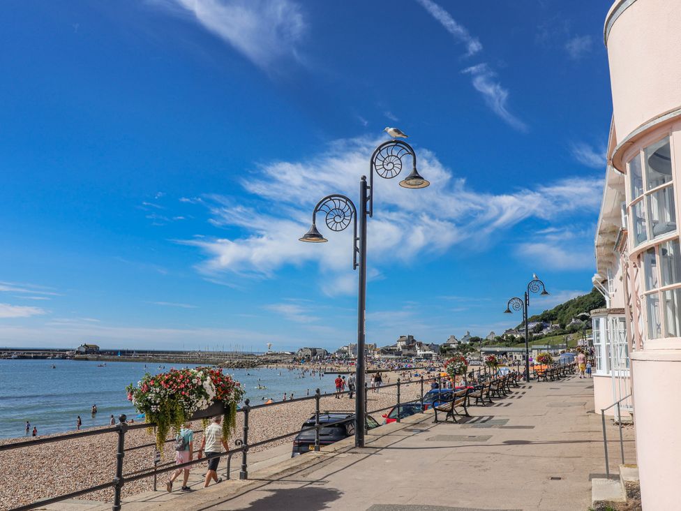 A beach with people and lampposts along the coast at Le Petit Glen in Uplyme