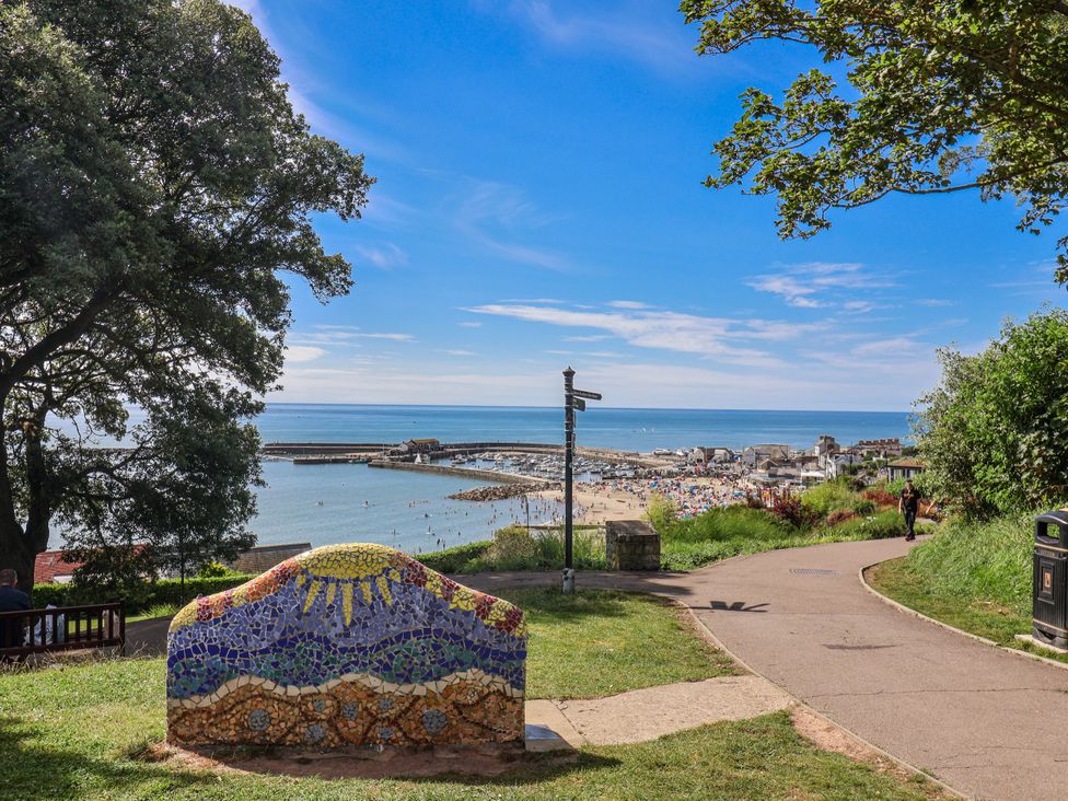 A view of a beach and sea with mosaic art at Le Petit Glen in Uplyme