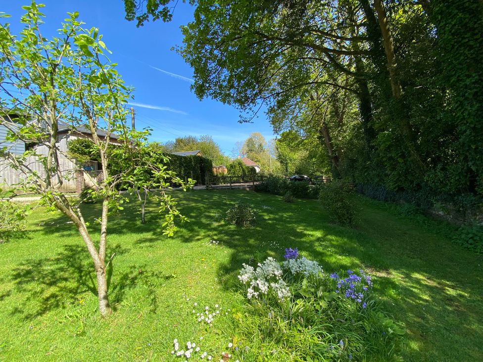 A garden with trees and flowers at Le Petit Glen in Uplyme