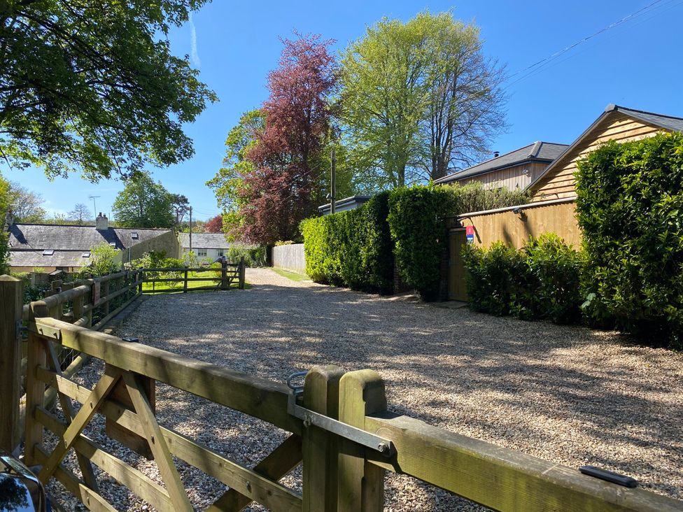An outdoor area with gravel driveway and trees at Le Petit Glen in Uplyme