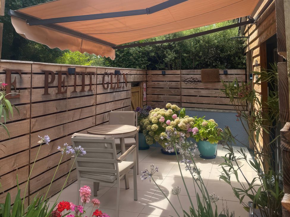 An outdoor area with a table and chairs at Le Petit Glen in Uplyme