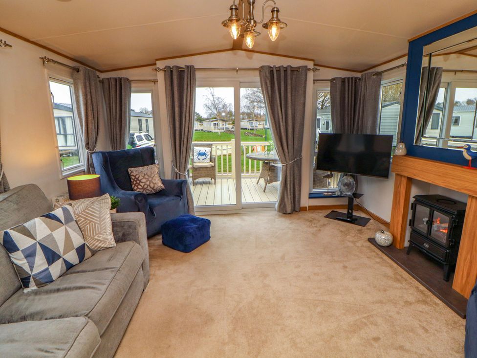 A living room with a sofa and an armchair at Hedgerow Lodge in Grange-Over-Sands
