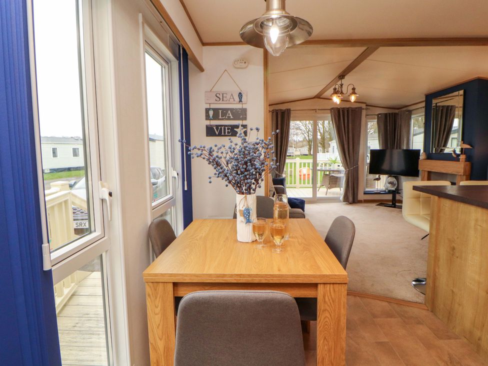A dining area with a wooden table and chairs at Hedgerow Lodge in Grange-Over-Sands