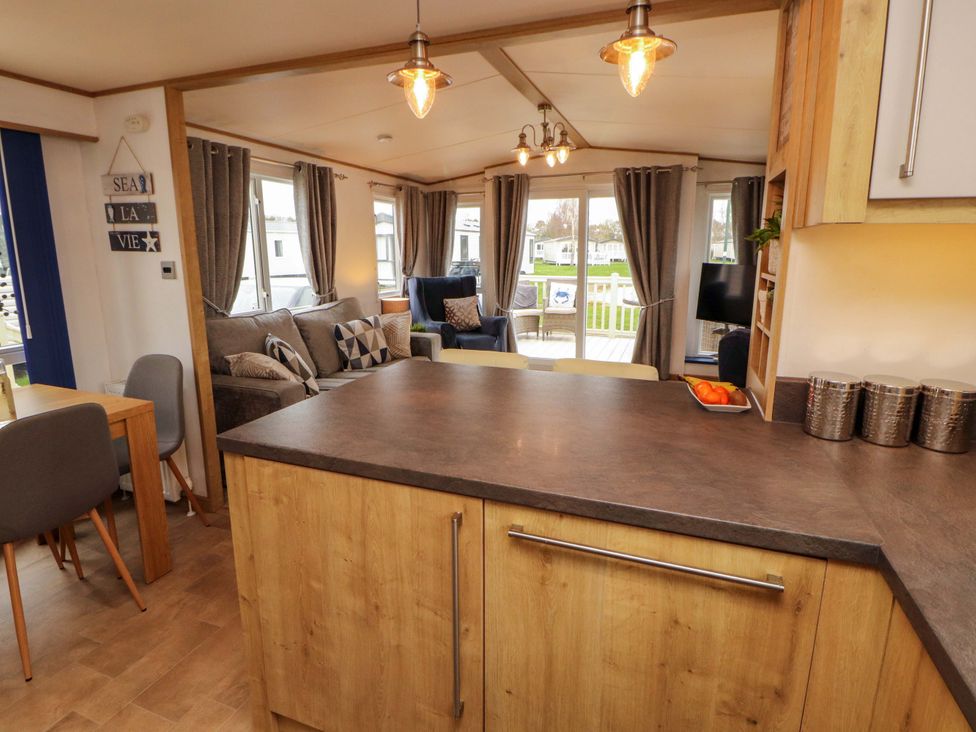 A living room with a table and chairs at Hedgerow Lodge in Grange-Over-Sands