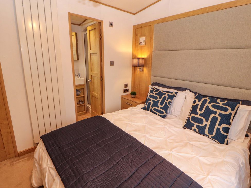 A bedroom with a bed and attached bathroom at Hedgerow Lodge in Grange-Over-Sands