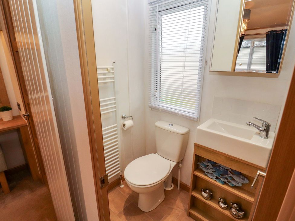 A bathroom with a toilet and sink at Hedgerow Lodge in Grange-Over-Sands