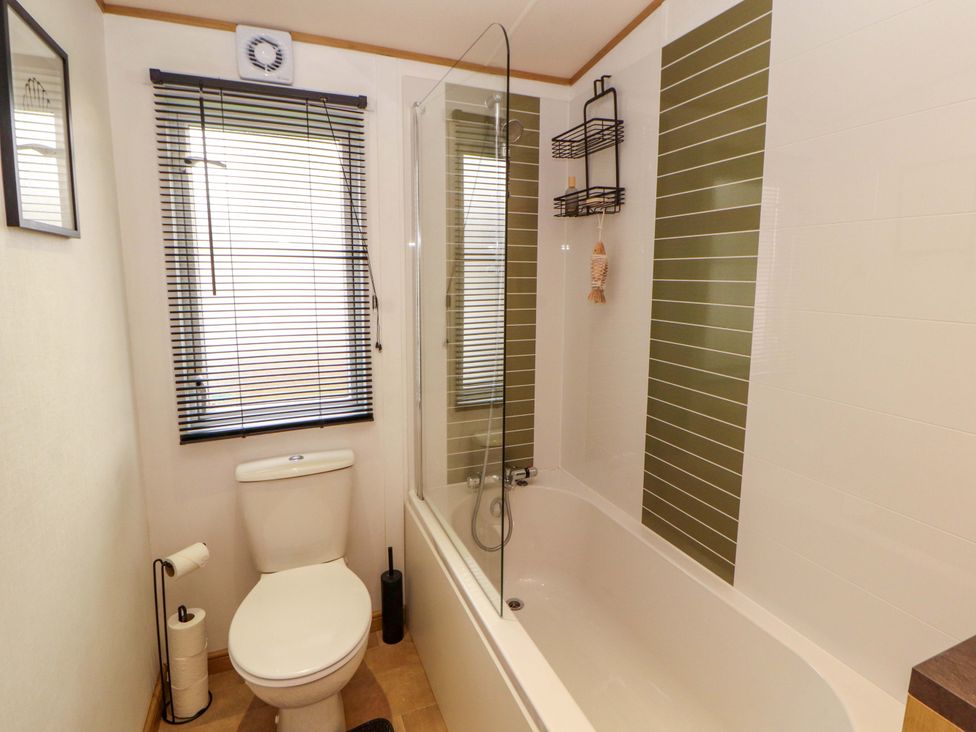 A bathroom with a bathtub and toilet at Hedgerow Lodge in Grange-Over-Sands