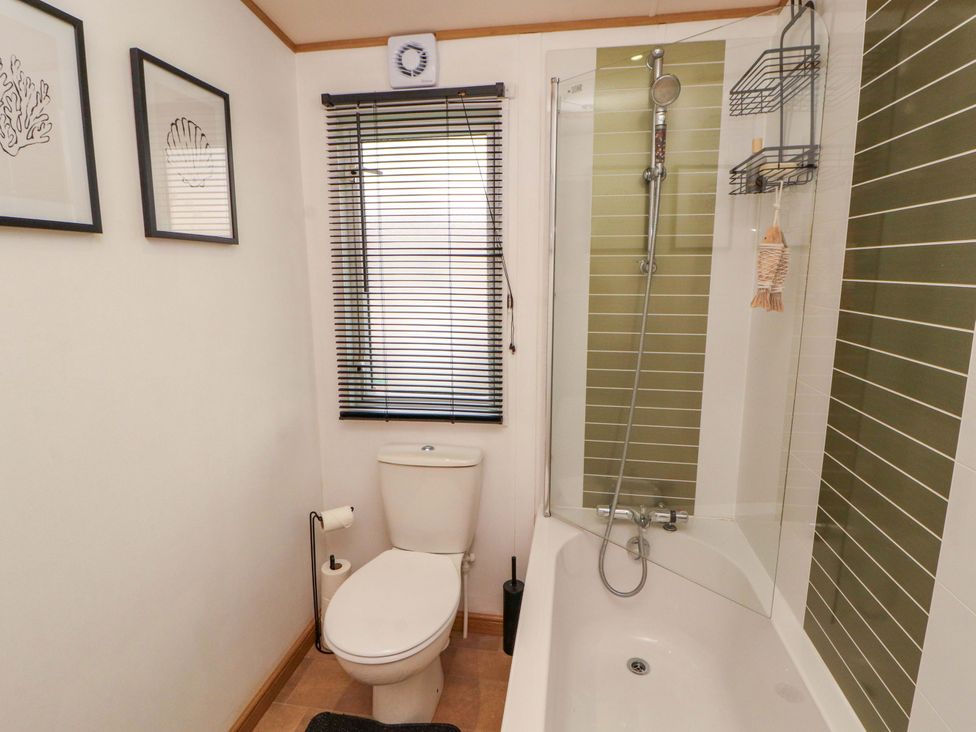 A bathroom with a bathtub and shower at Hedgerow Lodge in Grange-Over-Sands